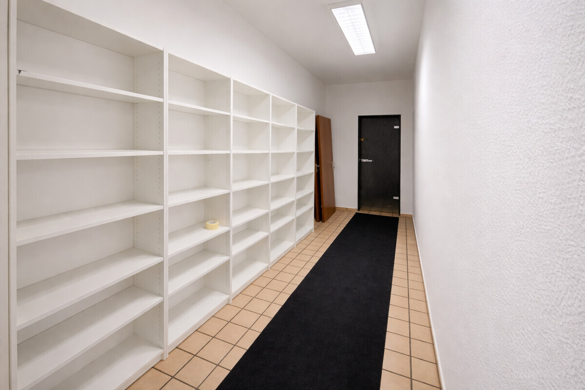 Leerer Flur mit weißen Bücherregalen