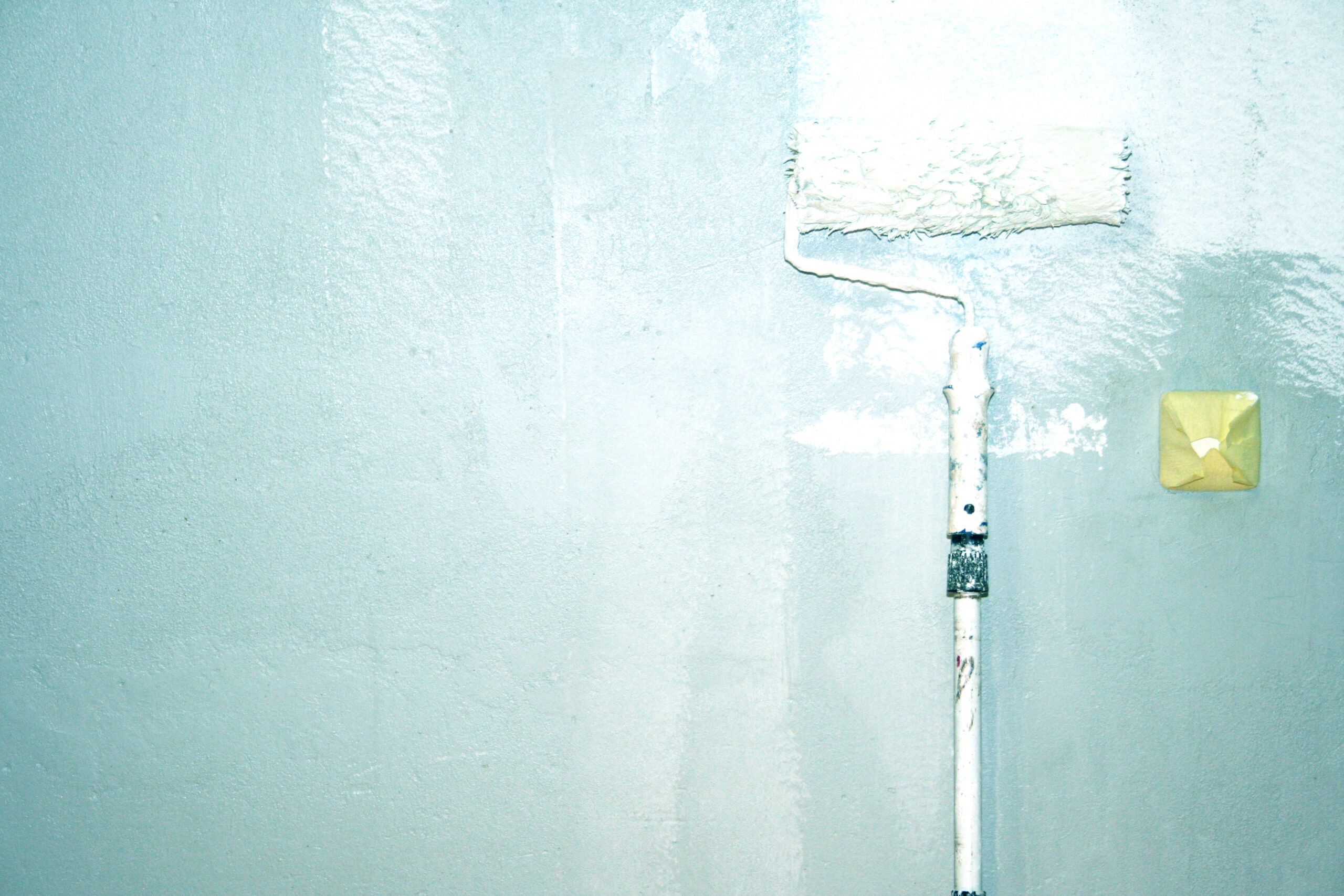 Eine blaue Wand wird weiß gestrichen: Änderungen in der Mietwohnung