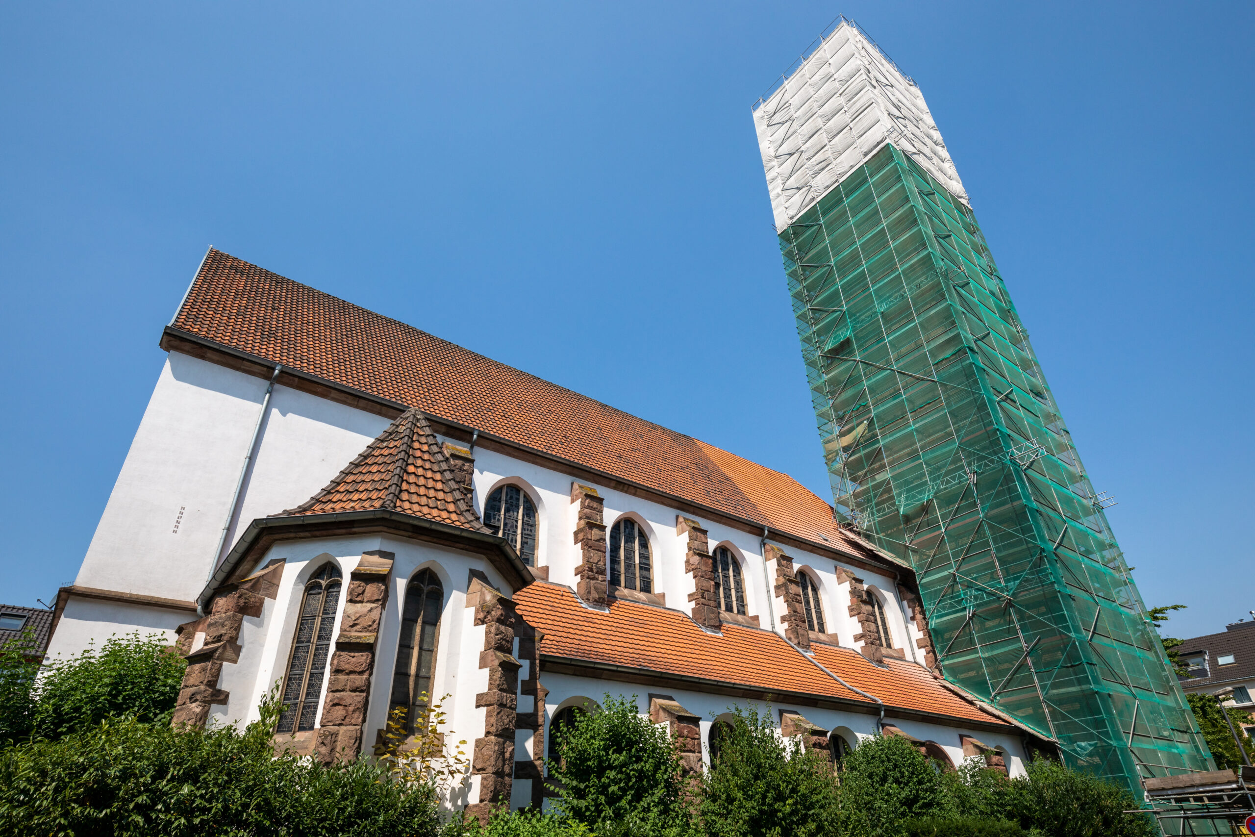 Die St. Pius-Kirche in Köln-Zollstock mit einem Gerüst um den Kirchturm