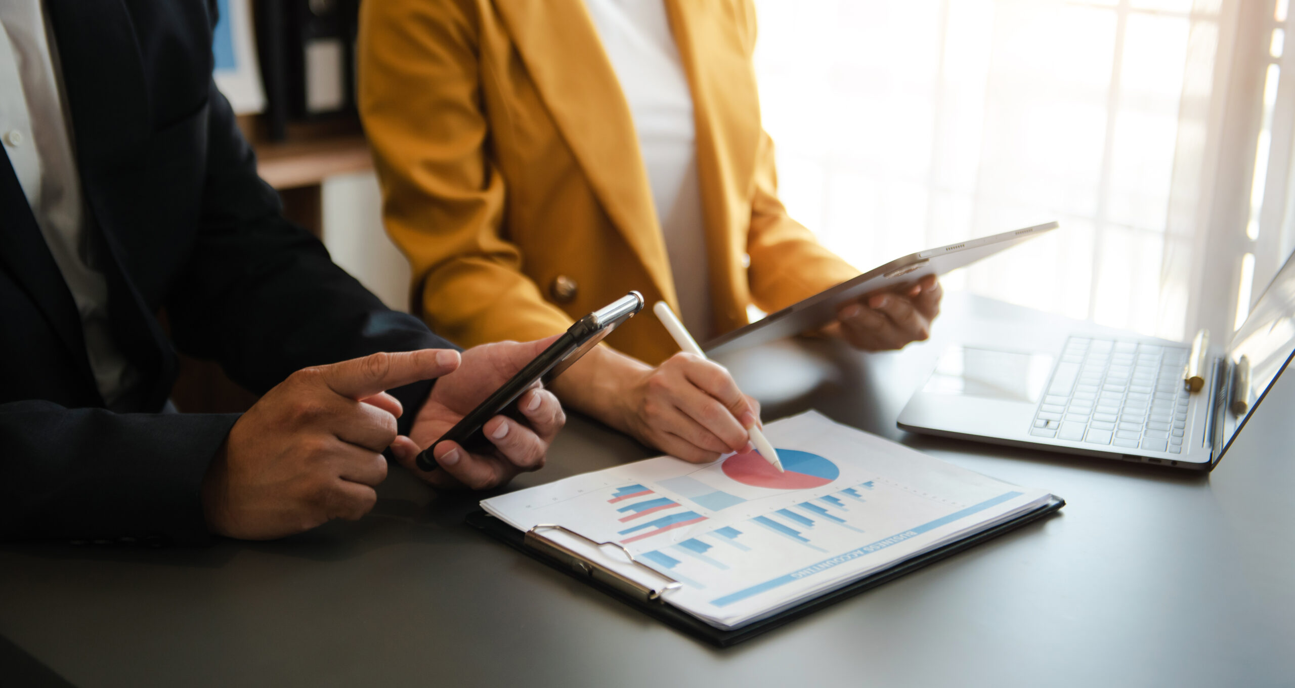 Zwei Personen besprechen Statistiken auf Papier