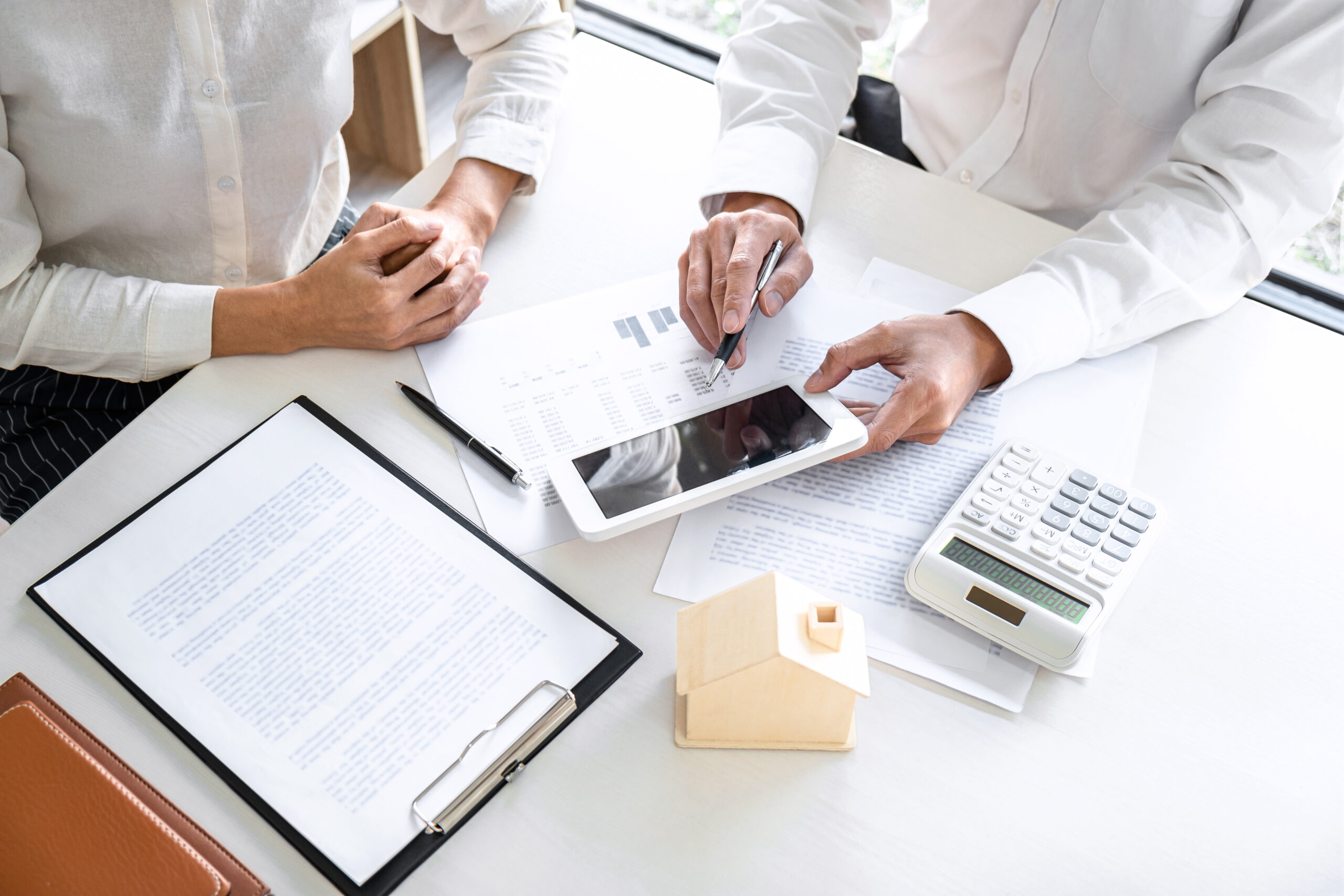 Zwei Immobilienmakler besprechen Vertragsdetails für einen Immobilienverkauf