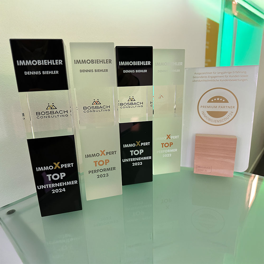 Diverse Auszeichnungen von ImmoBiehler auf einem Tresen im Maklerbüro