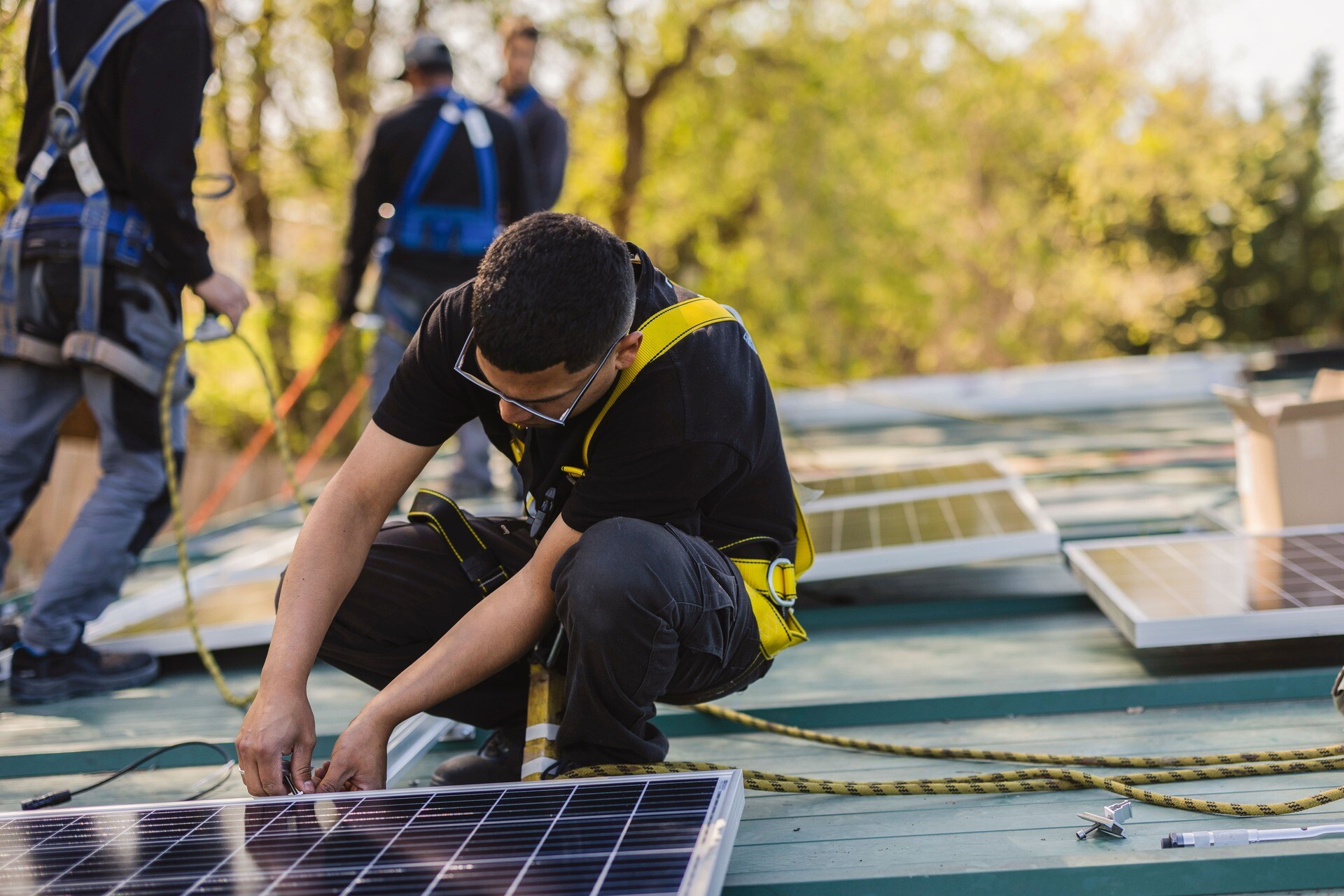 Techniker installiert Solarpaneele, Beispiel für energetische Maßnahmen
