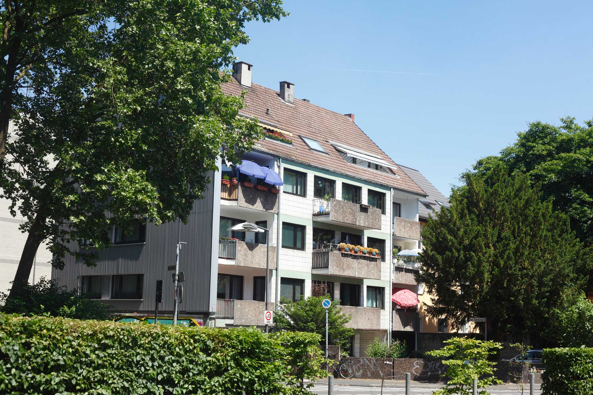 Blick auf ein altes Mehrfamilienhaus, Symbol für Mängel an Immobilien in Köln