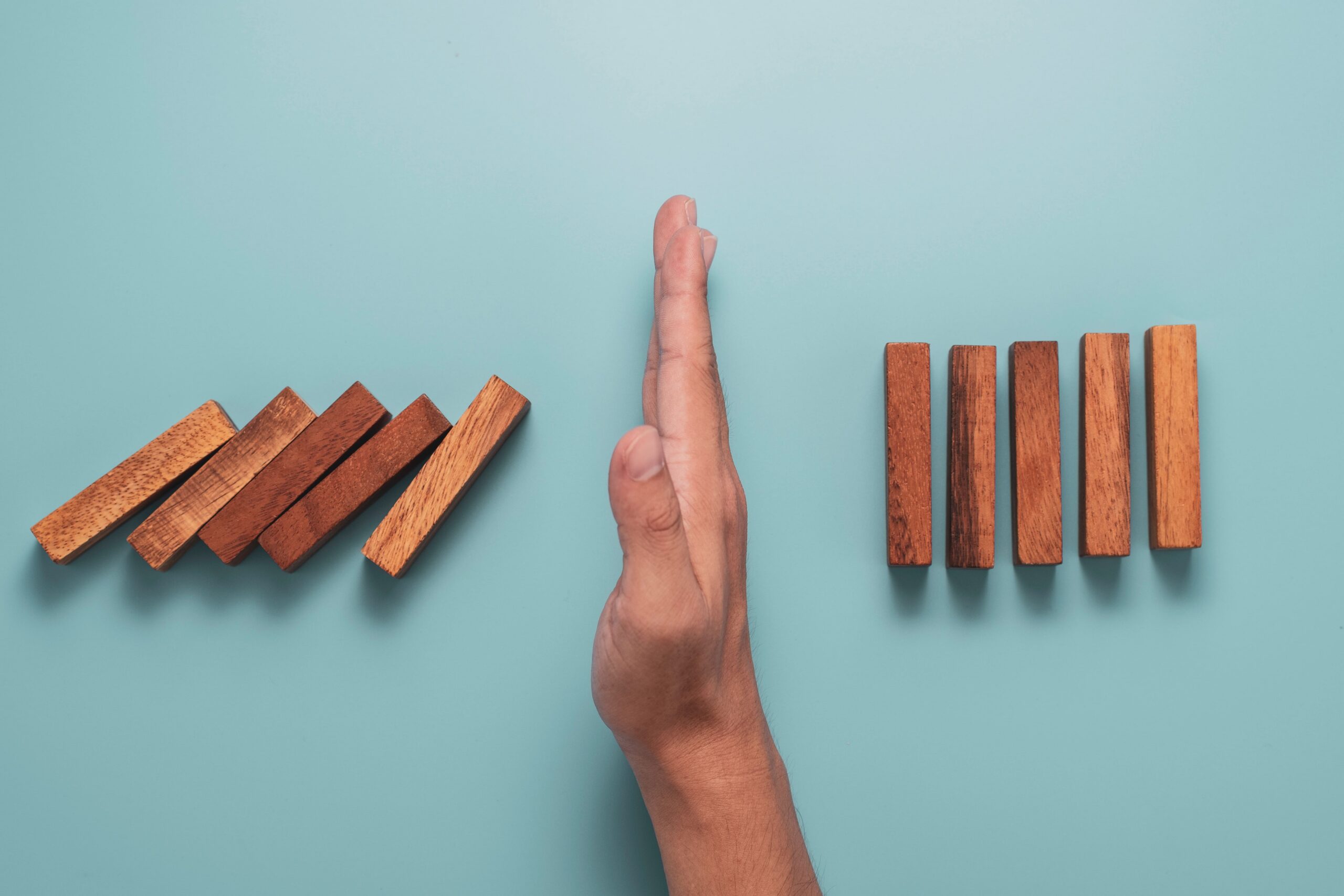 Dominosteine, die von Hand gestoppt werden