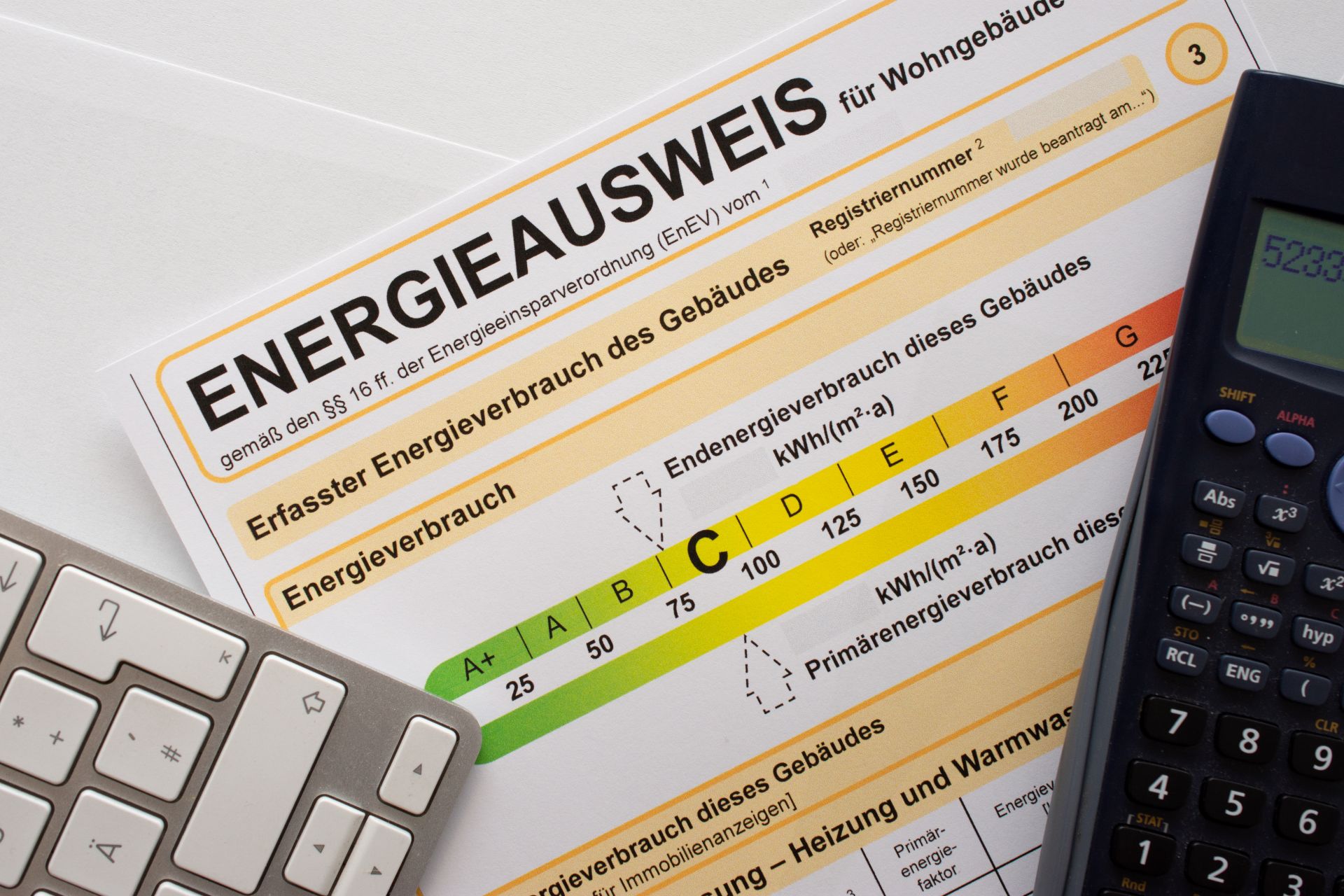Deutscher Energieausweis, mit Rechner und Tastatur.