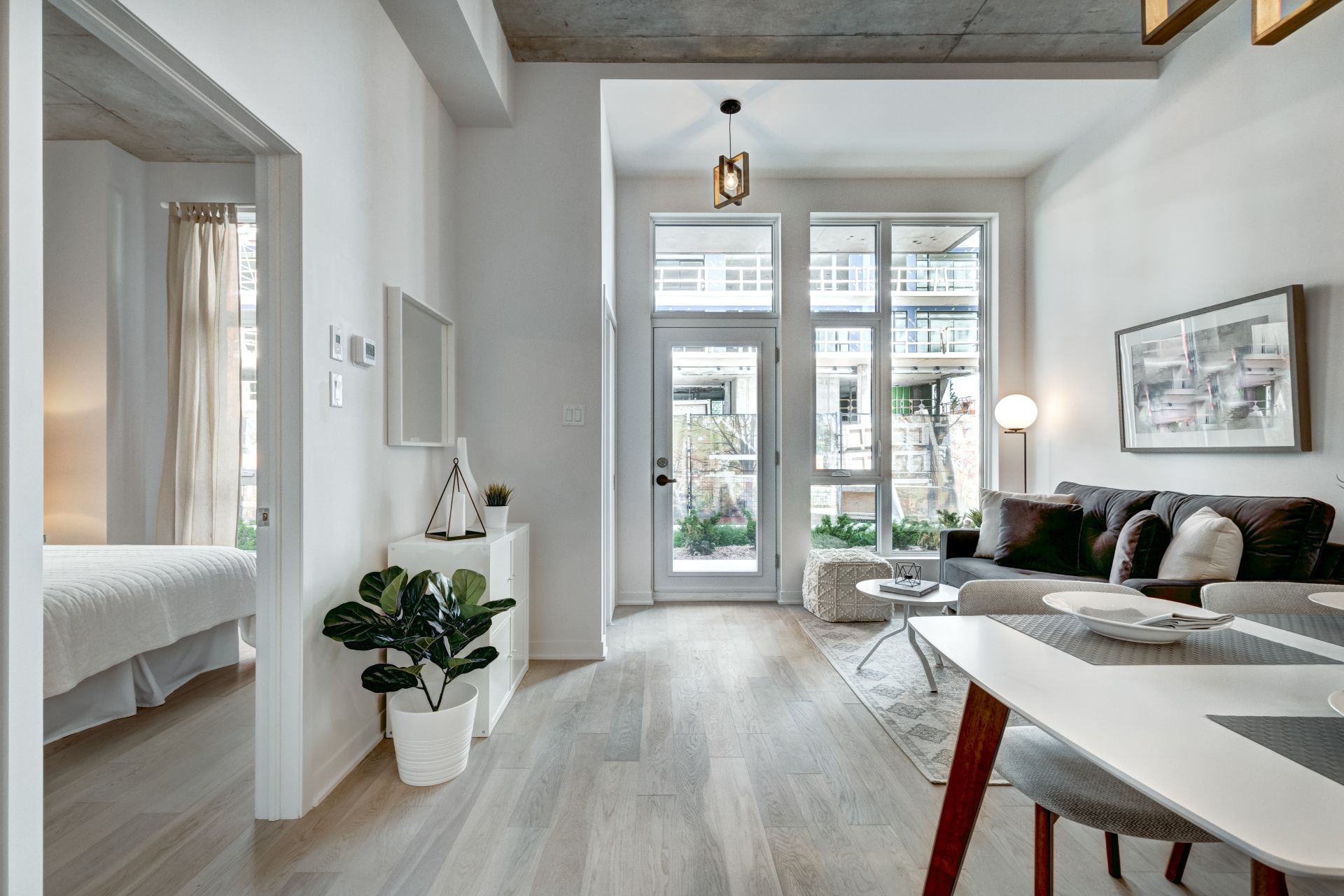 Moderne Wohnung, große Fenster, helle Holzböden, minimale Ausstattung.