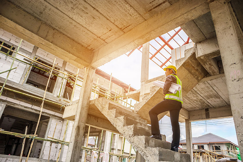 Architekt mit Plänen auf der Baustelle: Beitragsbild Verzug & Rücktritt bei Bauträgerprojekten
