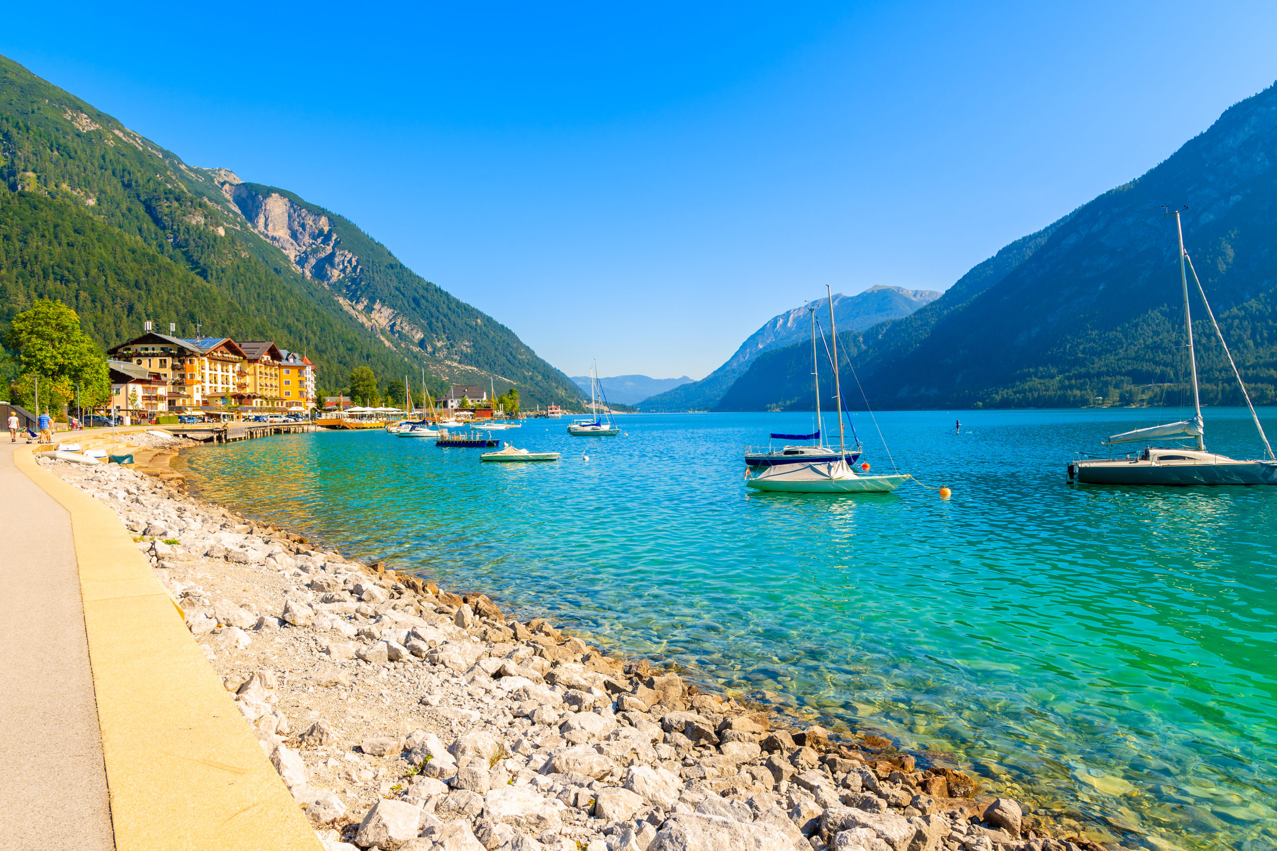 Strandansicht Achensee mit kleinen Yachten und Häusern und Bergen im Hintergrund