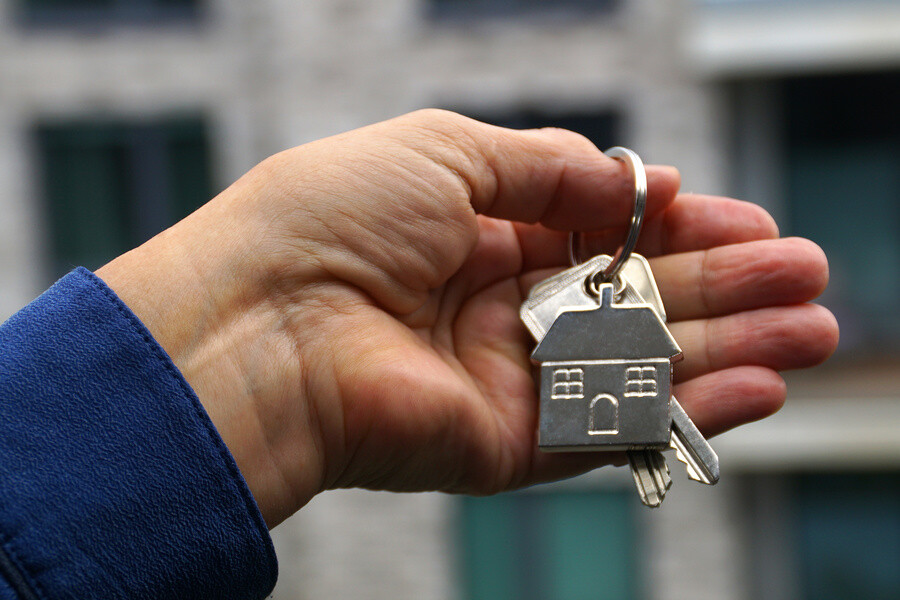 Mann hält einen Schlüssel in der Hand