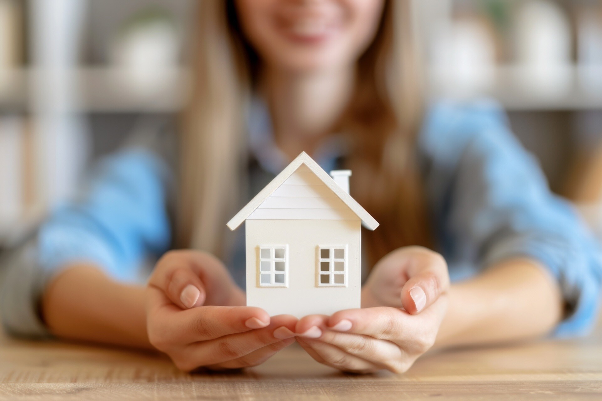 Lächelnde Frau mit Modellhaus