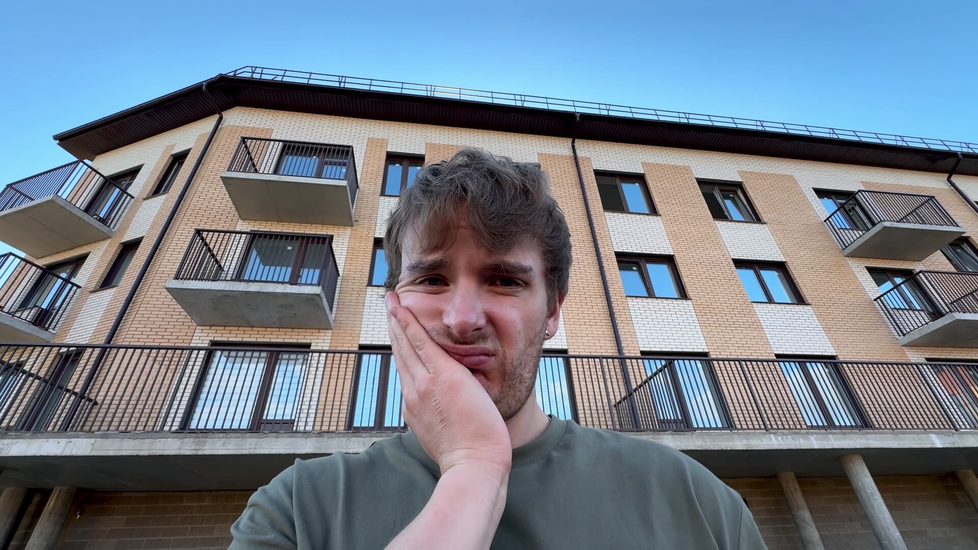 Verzweifelter Mann vor einem Mehrfamilienhaus