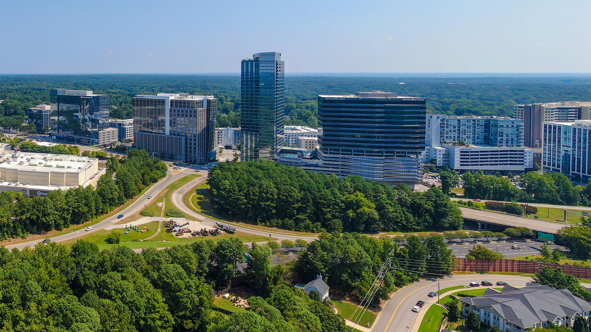 Stadt mit hohen Gebäuden, Straßen und Bäumen aus der Vogelperspektive.