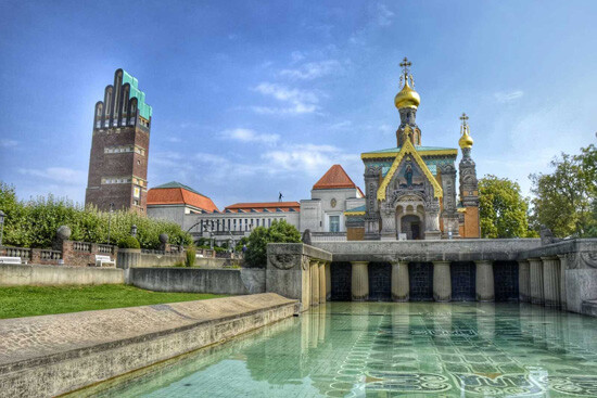 Kirche mit goldenen Kuppeln spiegelt sich im Pool bei Sonne.