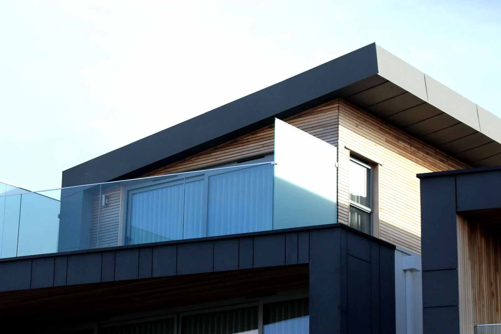 Modernes Haus mit Glasfront, Holzelementen und Schrägdach.