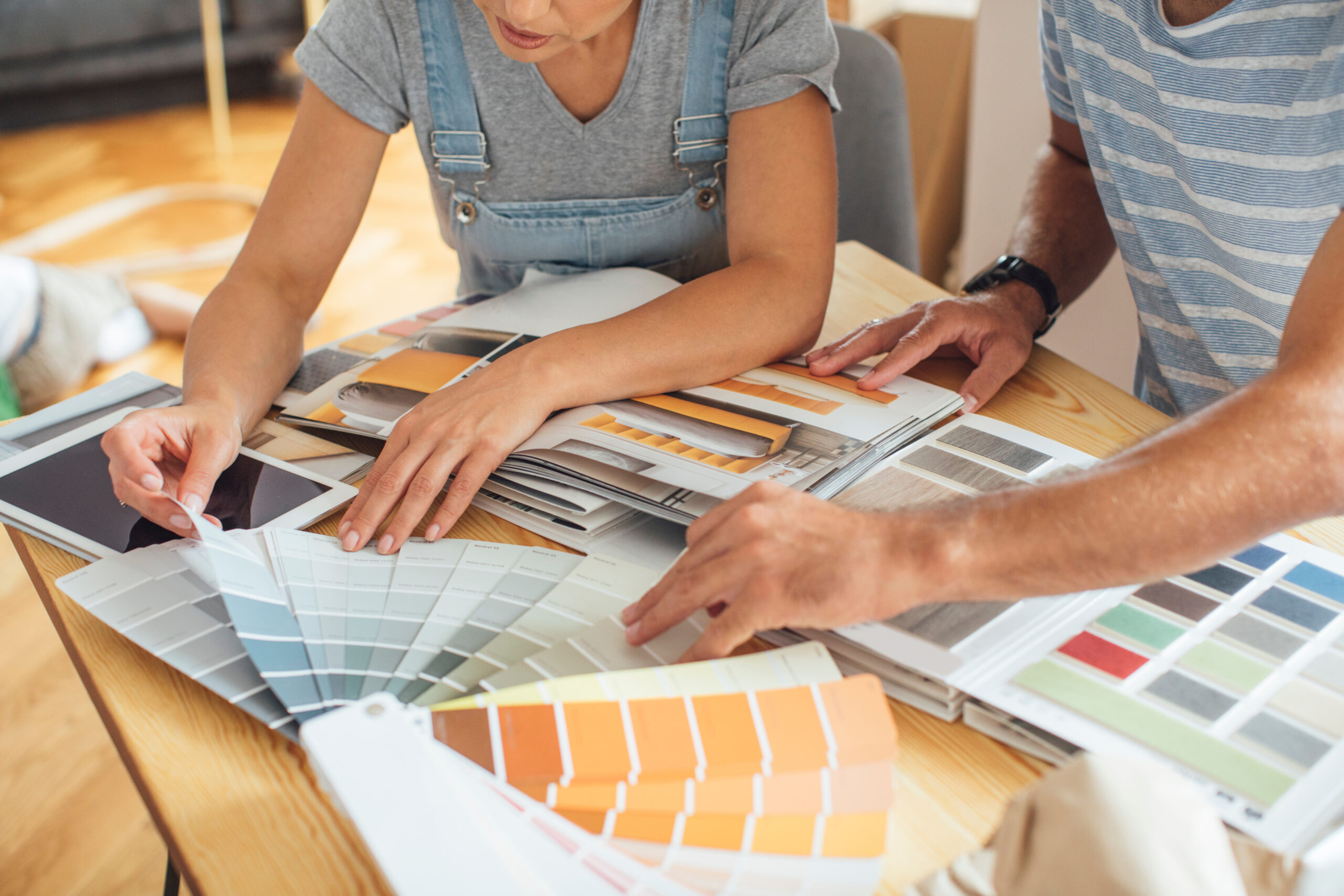 Mann und Frau planen Renovierung und schauen Farbmuster durch