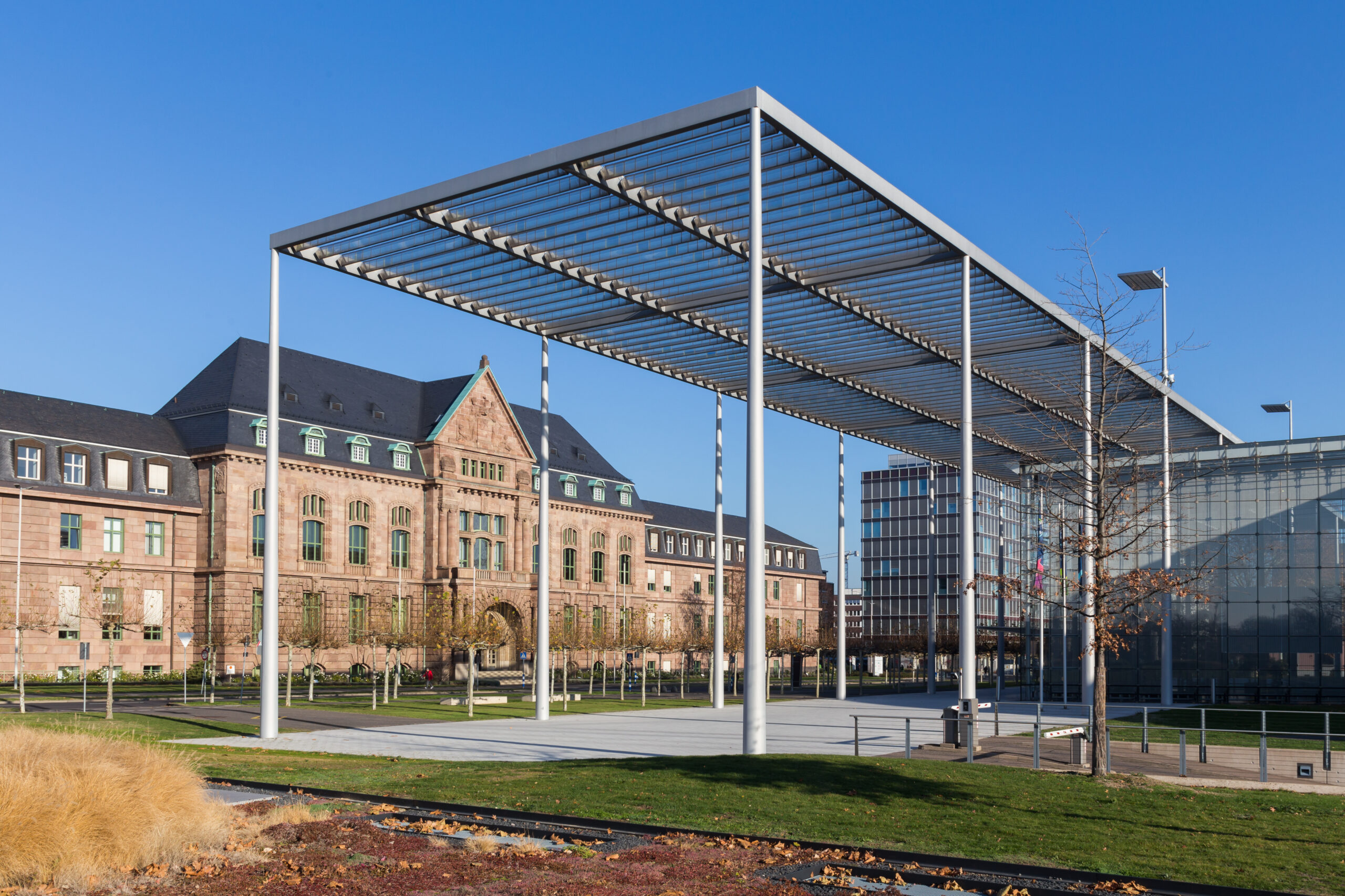 Metallpergola vor historischem Steingebäude bei blauem Himmel in Leverkusen