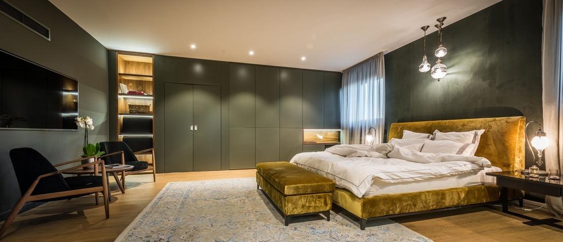 Modernes Master-Schlafzimmer mit Einbauschränken und Samtbett.