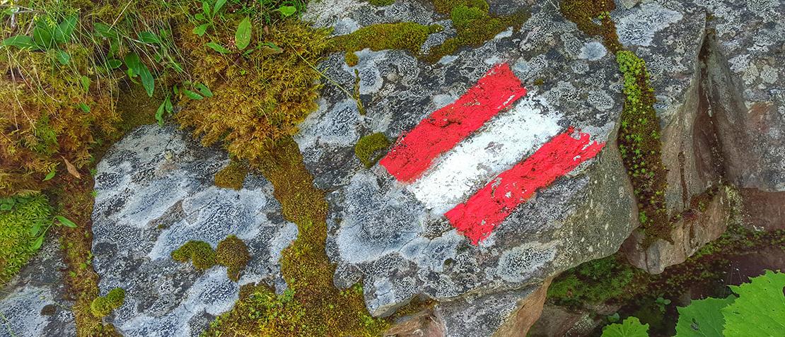 Österreich-Flagge aufgemalt mit Kreide auf Felsen.