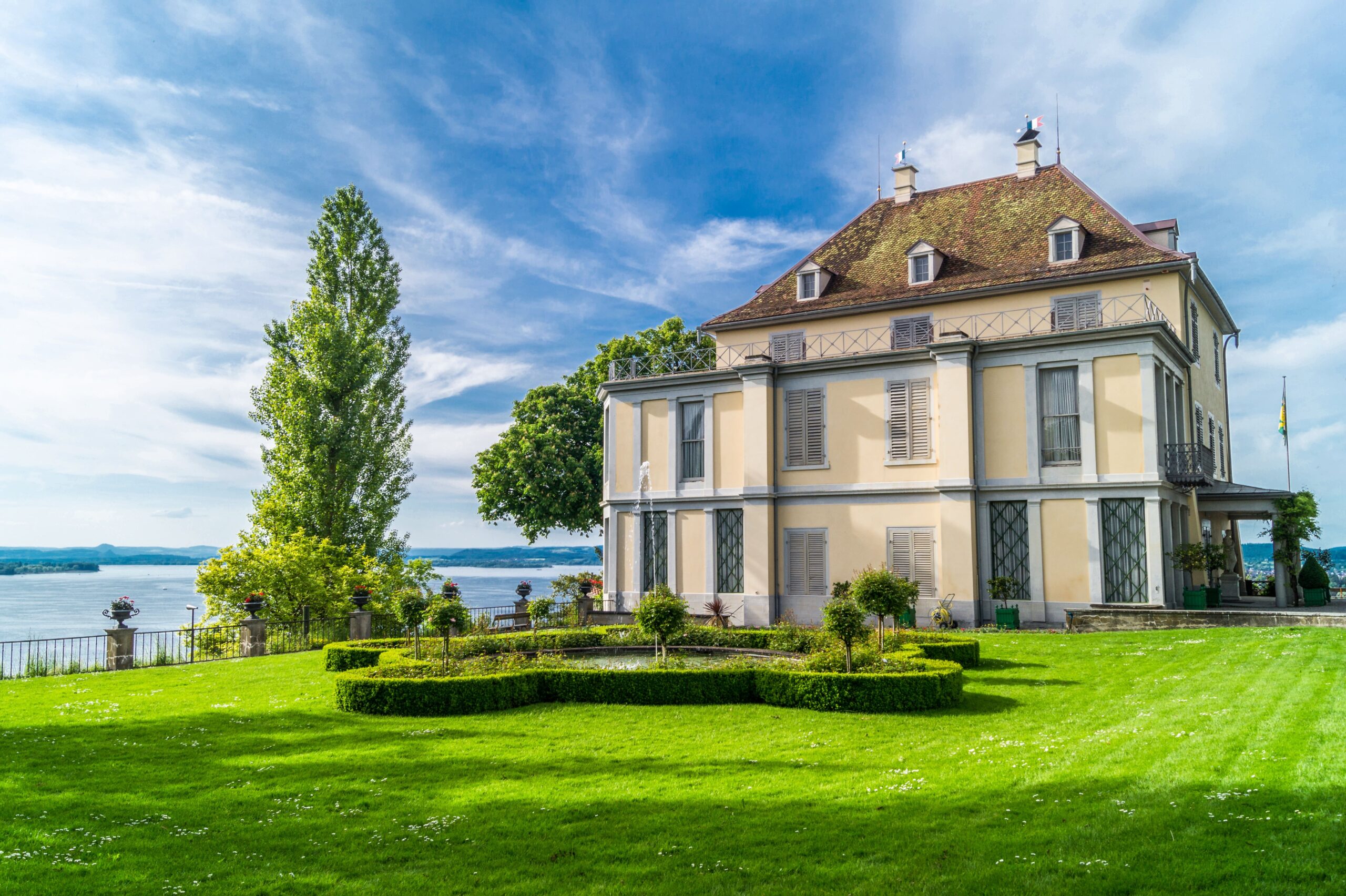 Historisches Schloss Arenenberg mit einer gepflegten Parkanlage und Panoramablick auf den Bodensee.
