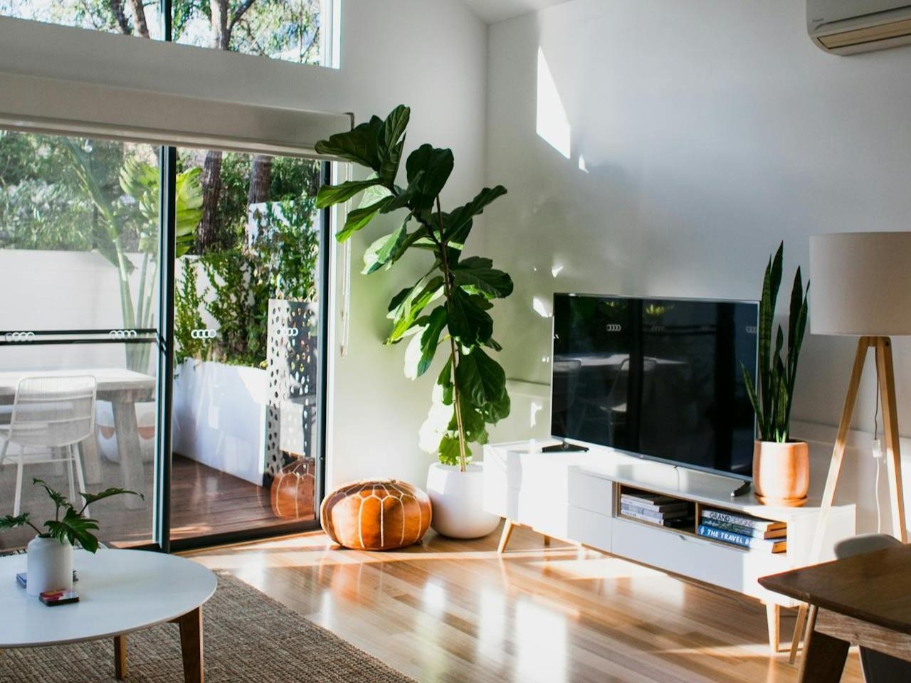 Heller Wohnbereich mit Holzboden und großer Schiebetür zur Terrasse.