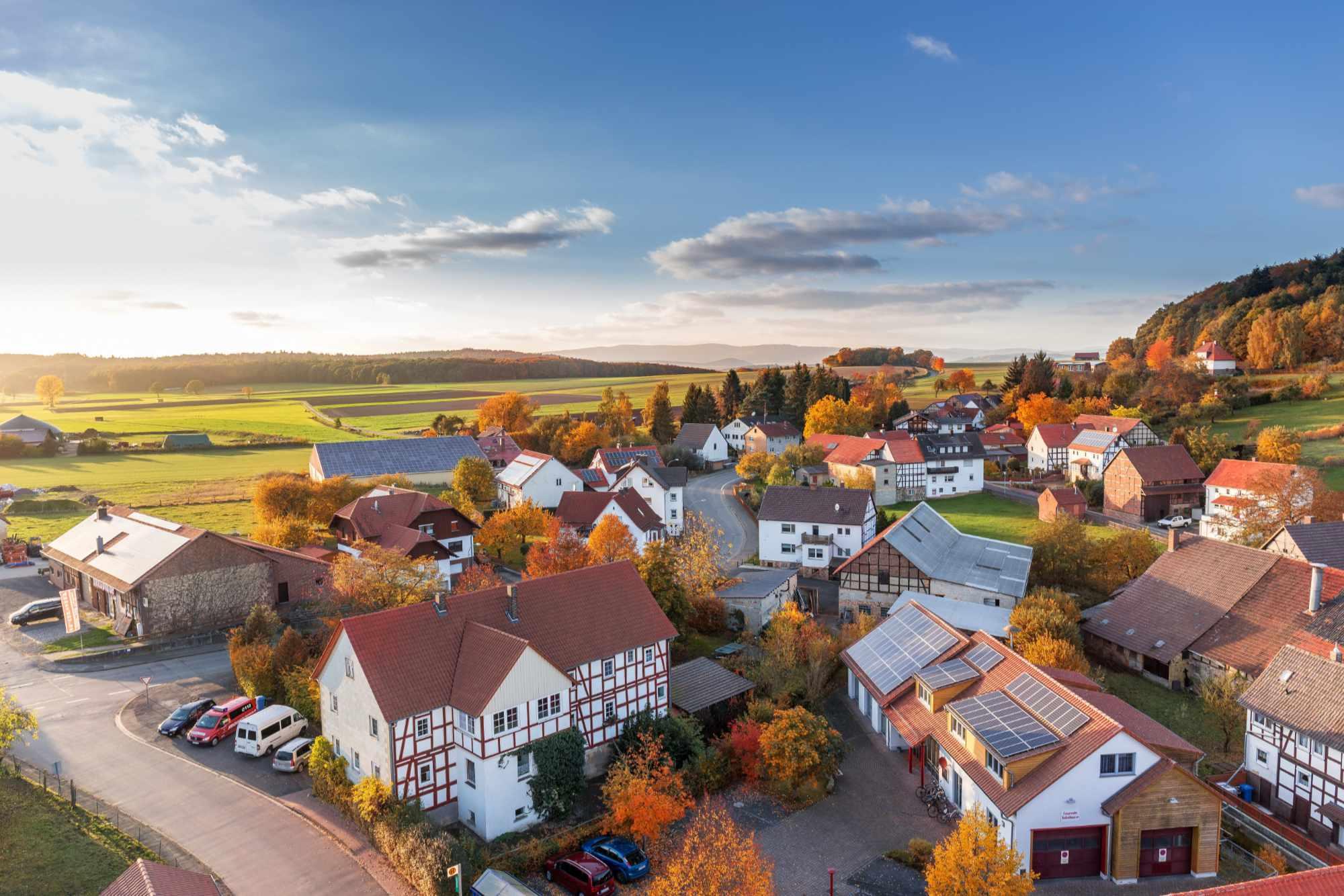 Idyllisches Dorf-Panorama mit Fachwerkhäusern und grüner Umgebung.