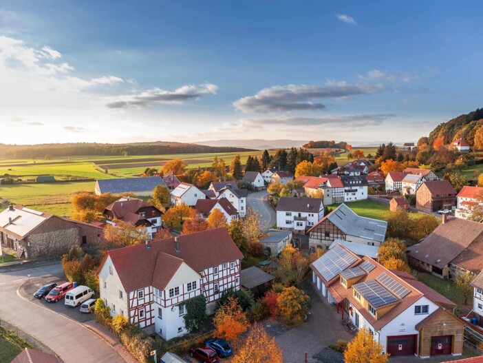Idyllisches Dorf-Panorama mit Fachwerkhäusern und grüner Umgebung.