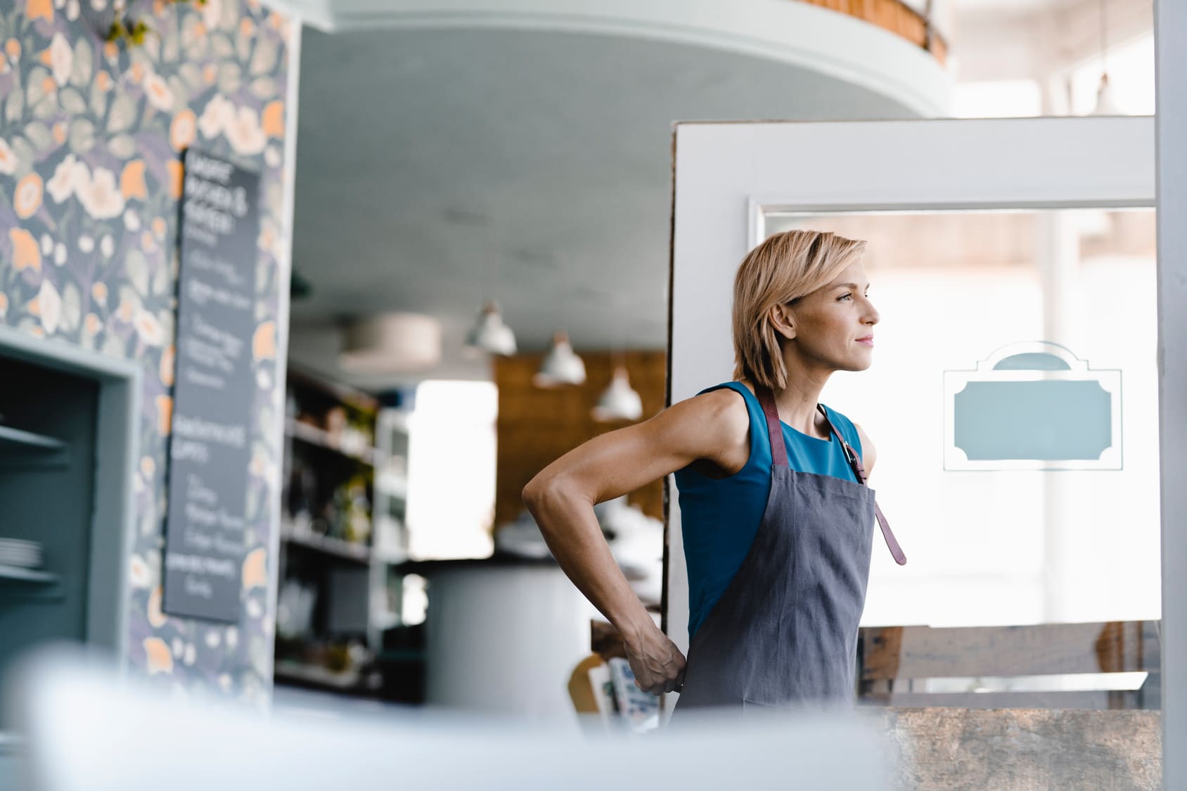 Freu bindet sich Schürze in Geschäft