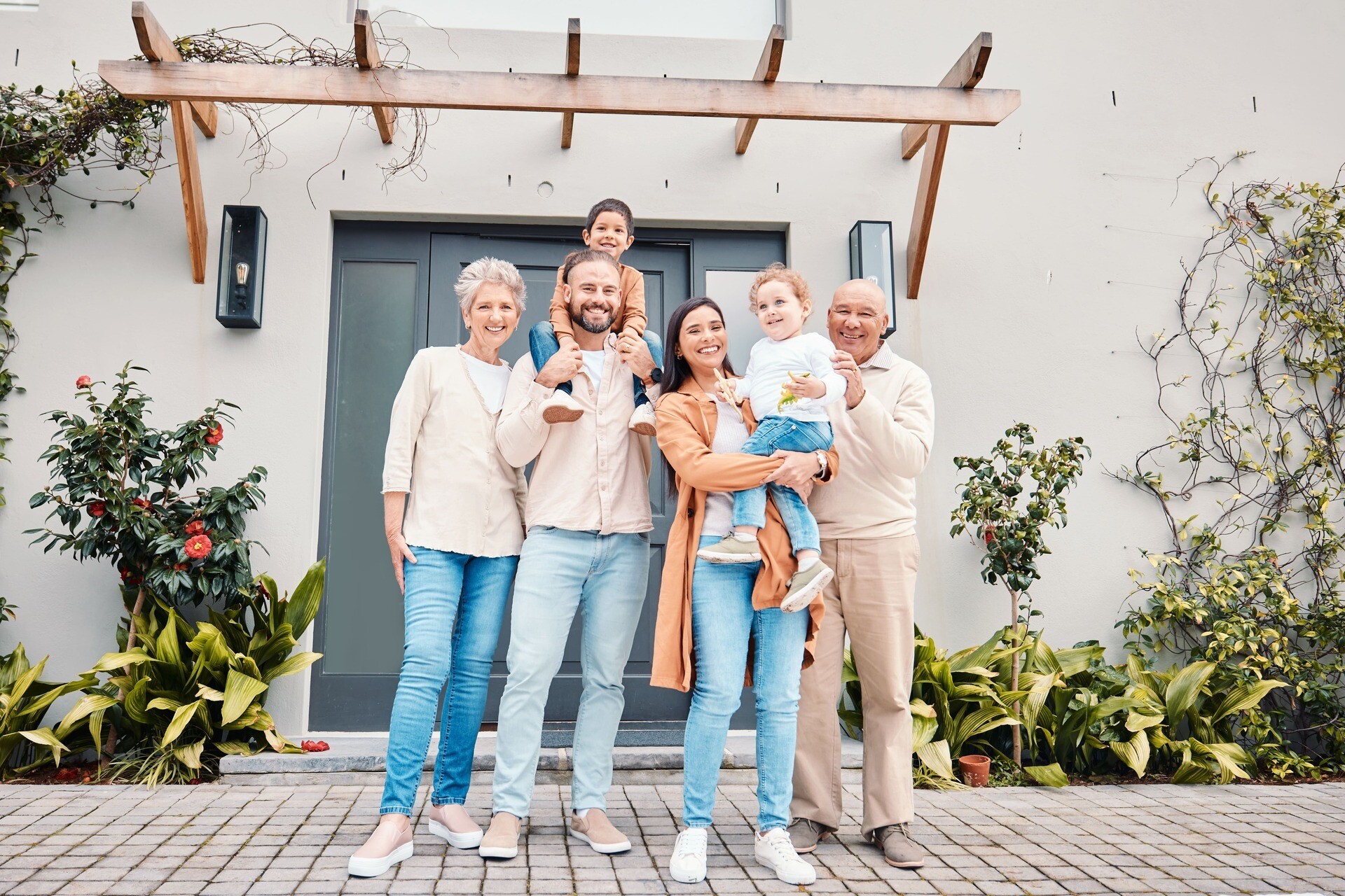 Mehrere Generationen einer Familie vor einem Haus