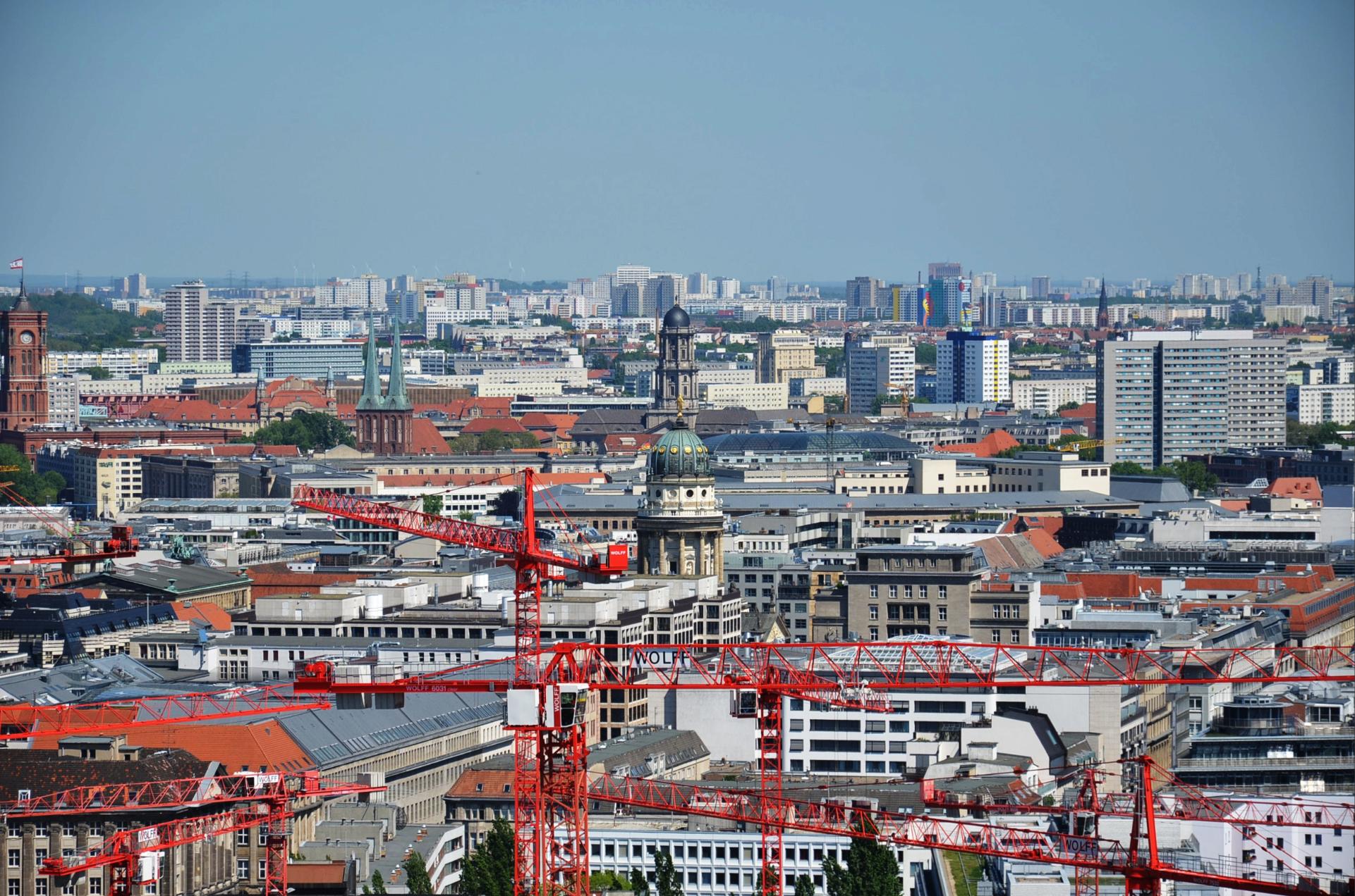 Blick über die Berliner Innenstadt mit historischen Gebäuden und Baukränen.
