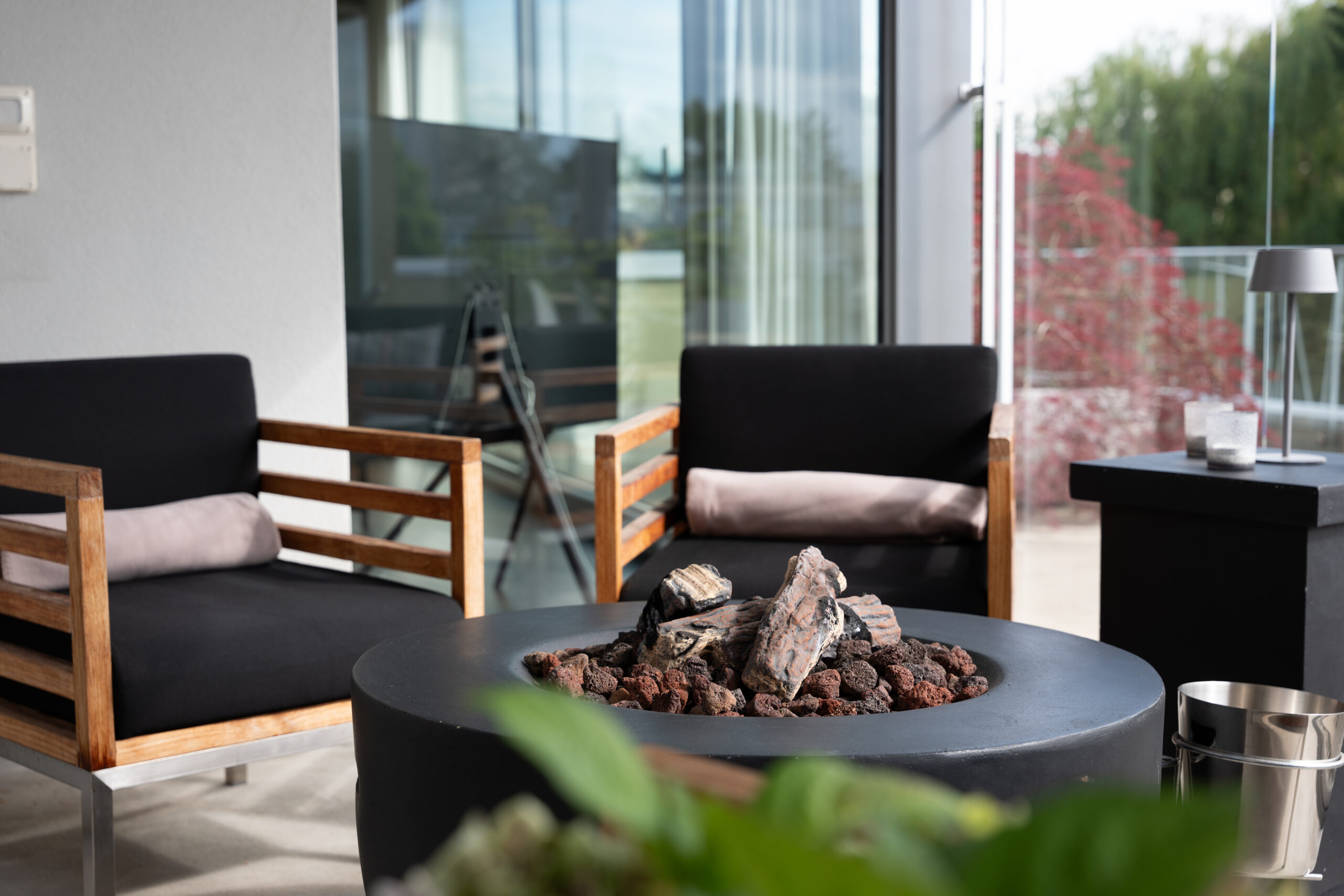 Wintergarten mit moderner Feuerstelle und Sesseln