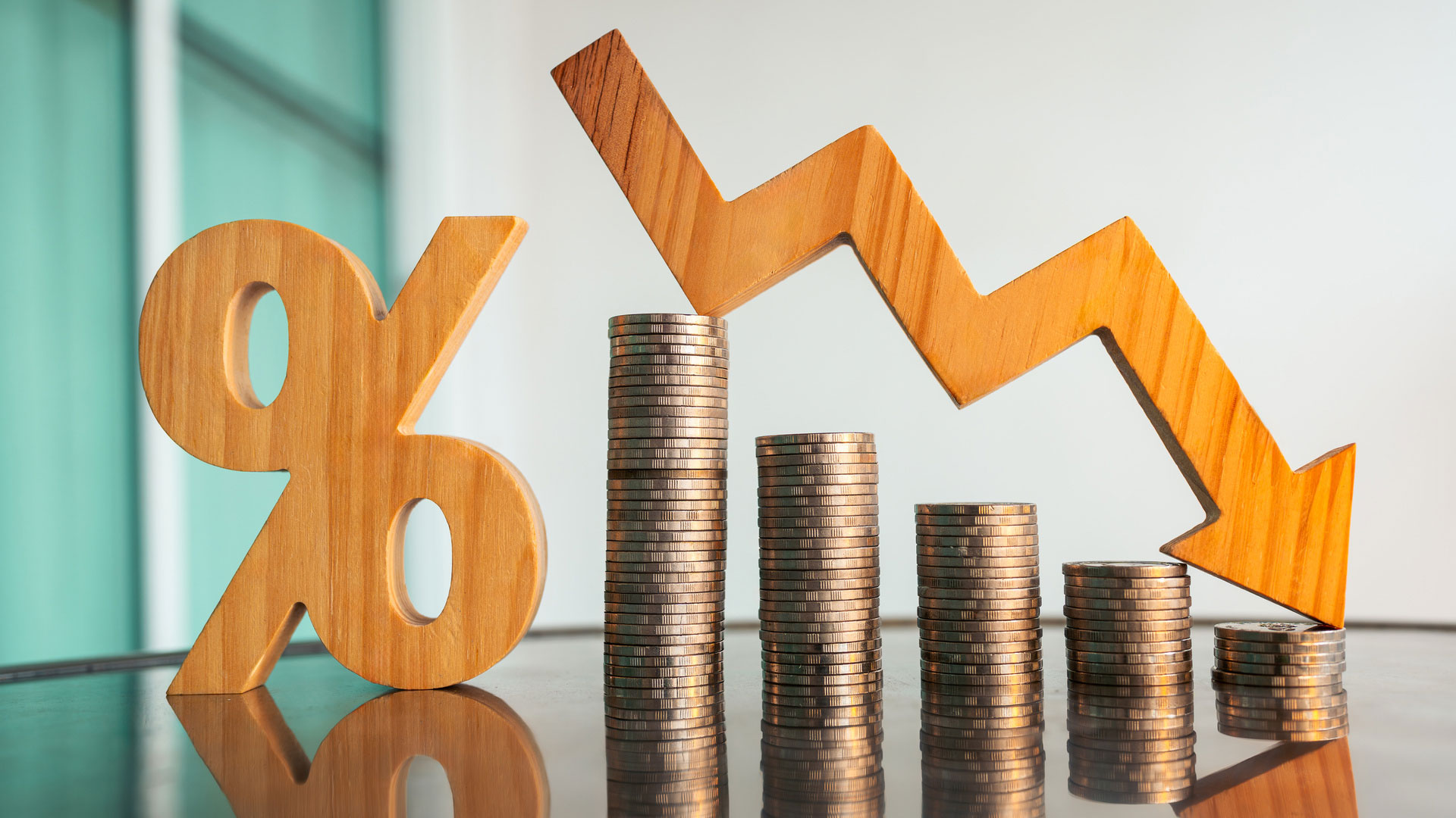 Münztürme mit Prozentzeichen und fallendem Pfeil