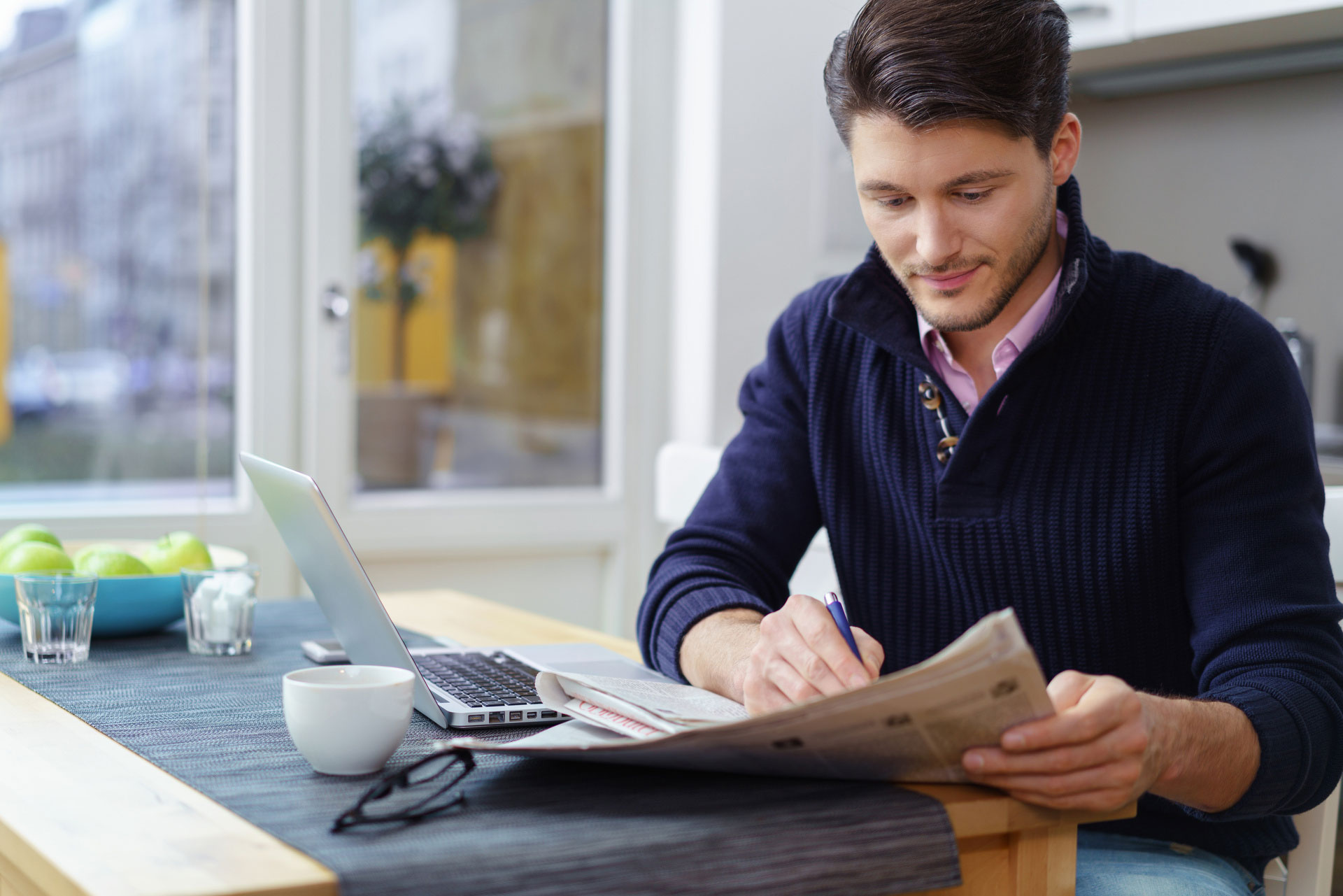 Mann am Esstisch mit Zeitung