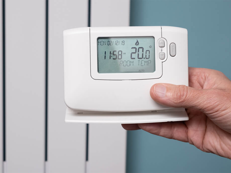 Mann hält Wetterstation in der Hand