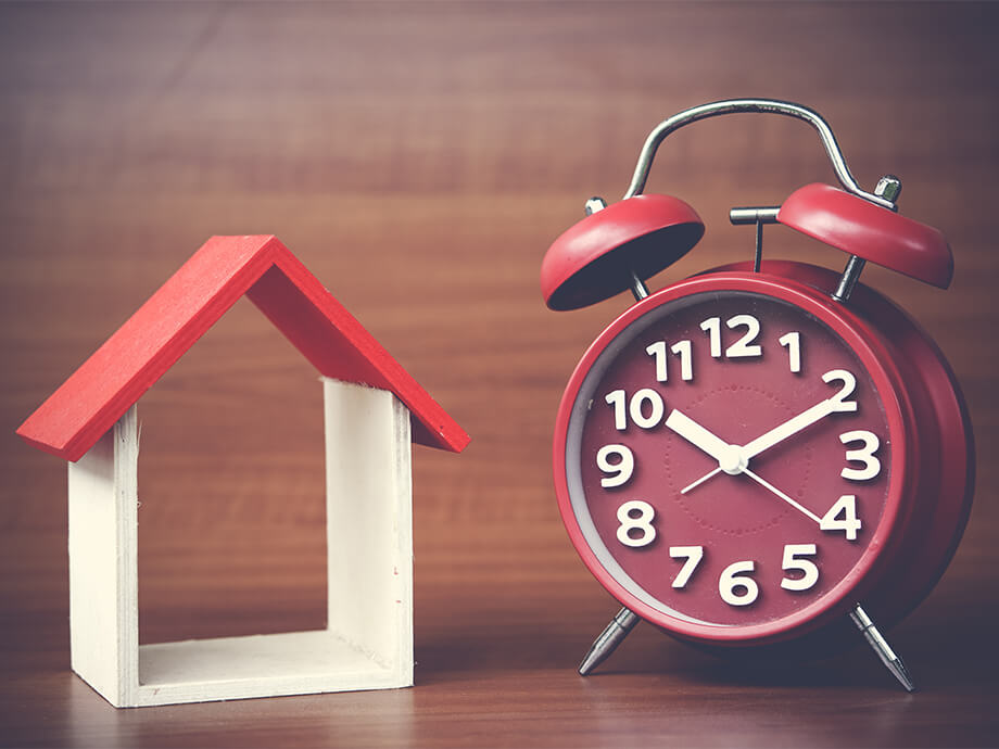 Hausumriss und roter Wecker