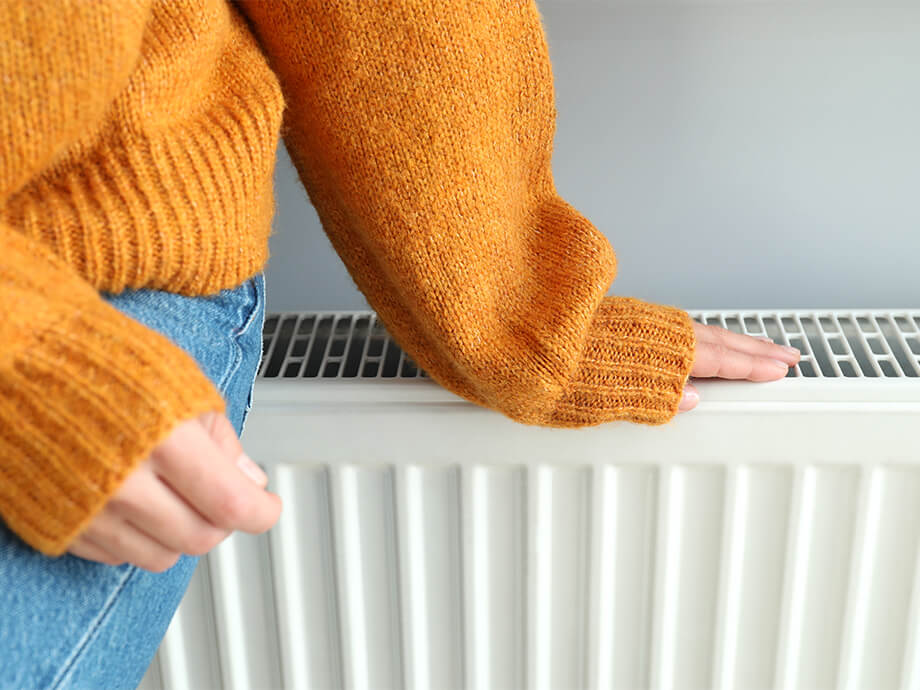 Frau lehnt an Heizung