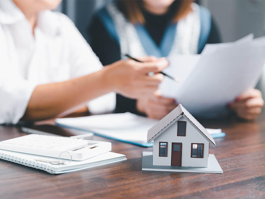 Hausmodell mit Paar im Hintergrund