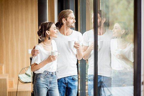 Junges Paar sieht aus dem Fenster