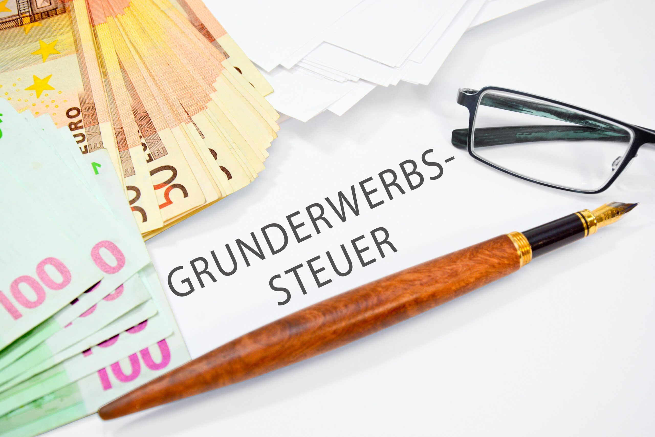 Grunderwerbssteuer mit Scheinen und Stift