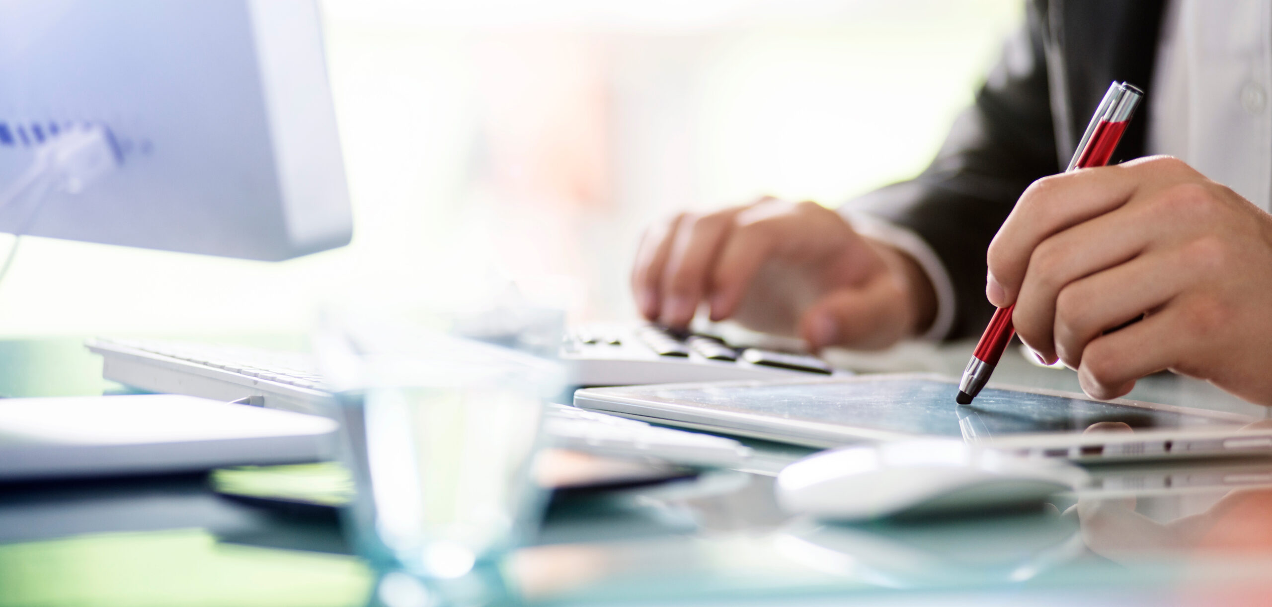 Geschäftsmann kalkuliert mit Tablet und Taschenrechner