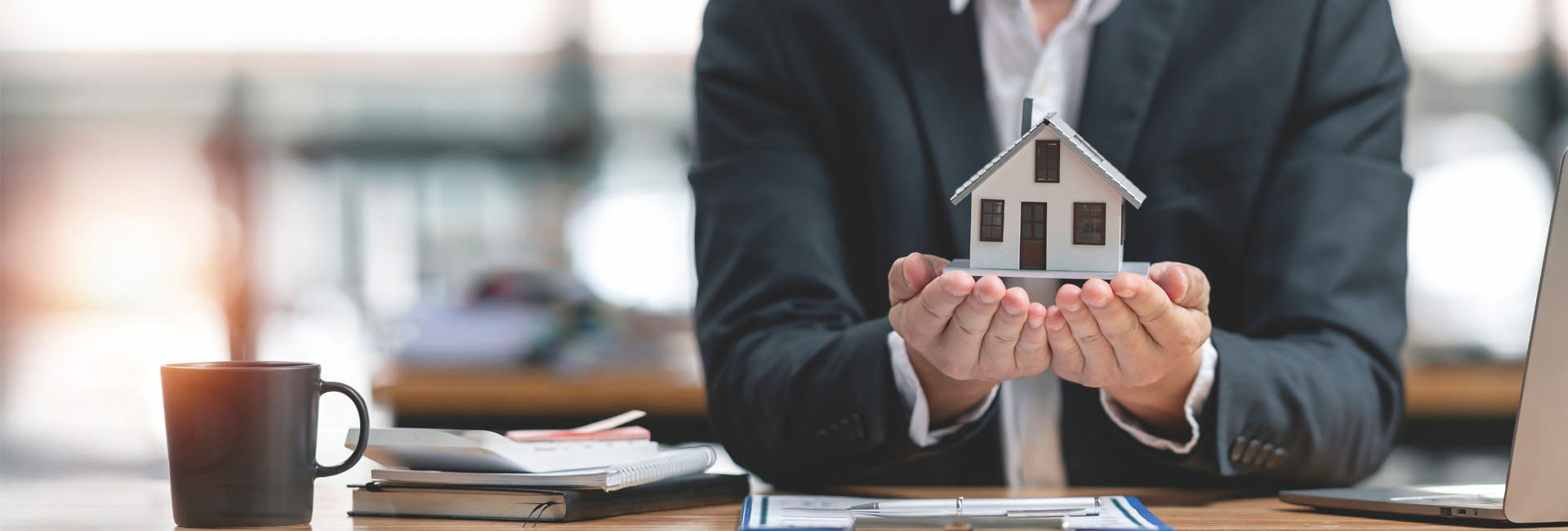 Modellhaus wird auf Händen hochgehalten