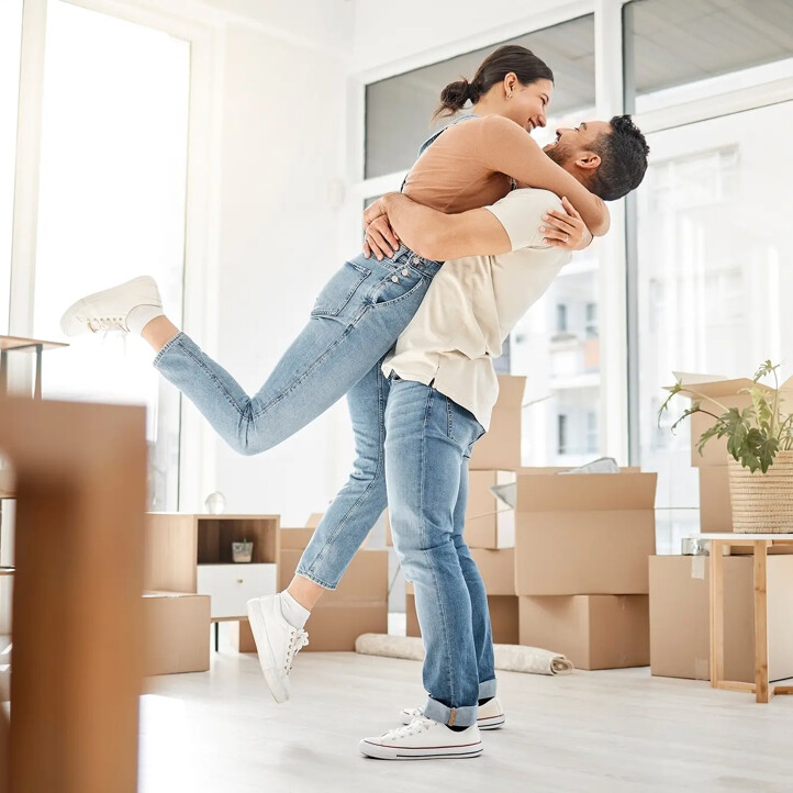 Liebe, Umzug und Umarmung eines Paares in ihrem neuen Zuhause – zur Feier, zum Immobilienkauf und zum Umzug. Aufgeregt, glücklich und Immobilien mit Mann und Frau im Wohnzimmer einer Wohnung – für Investitionen, zur Miete und als Eigenheim