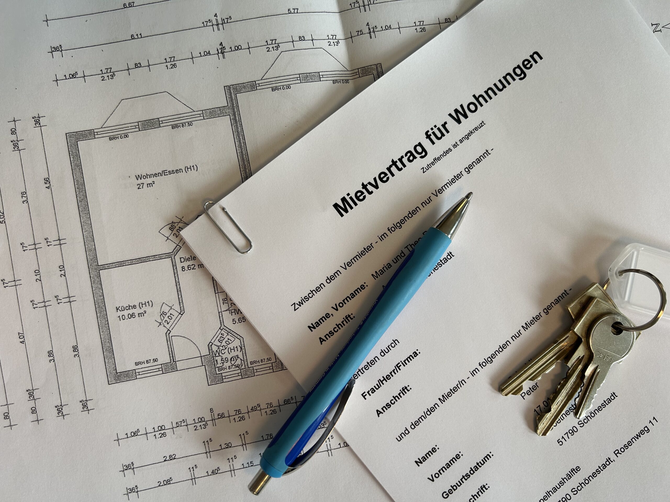 Mietvertrag mit Schlüsseln und Kugelschreiber