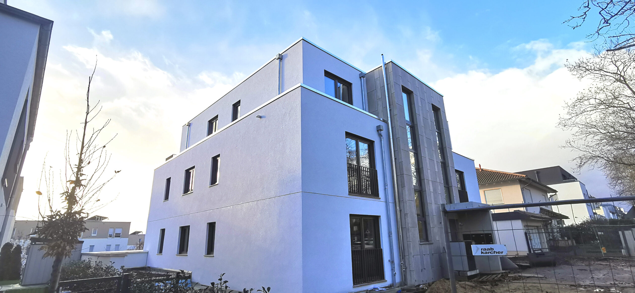 Dreistöckiges weißes Gebäude mit großen Fenstern, Baustelle.