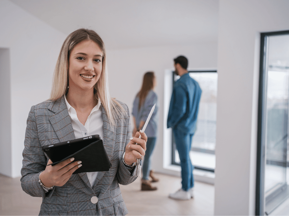 Agent mit Tablet und Paar besichtigen moderne Wohnung.