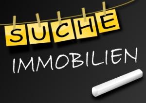 Tafel mit Aufschrift Immobiliensuche und Kreide