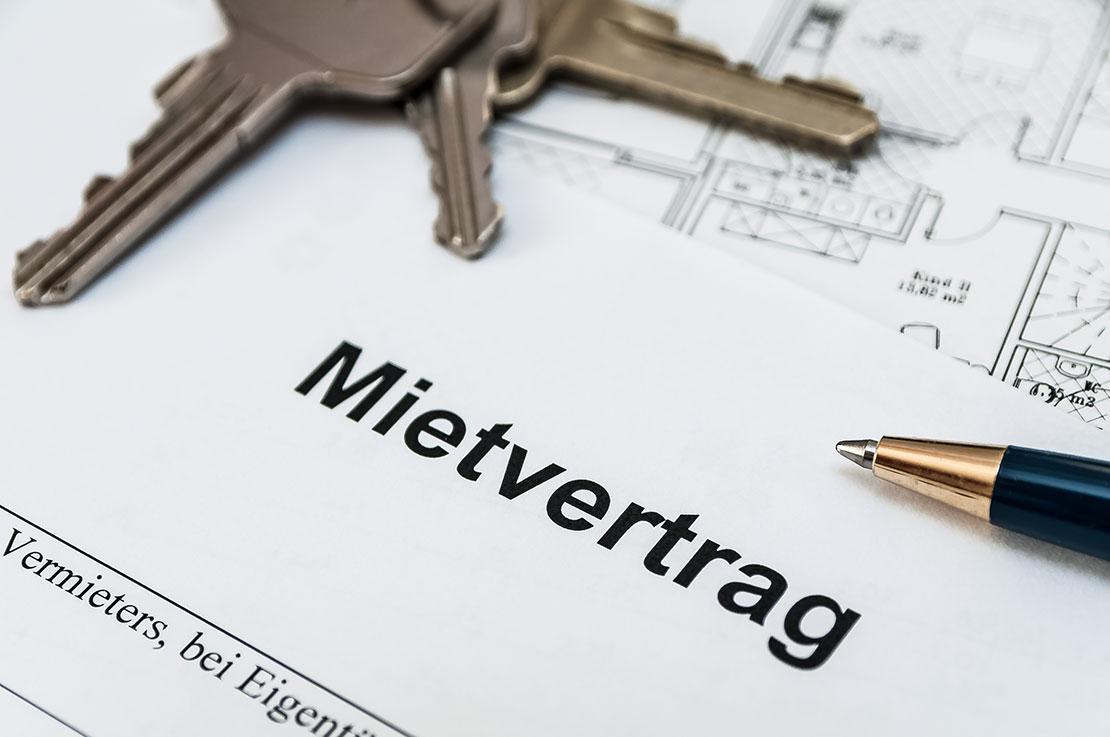 Mietvertrag mit Schlüsseln und Kugelschreiber