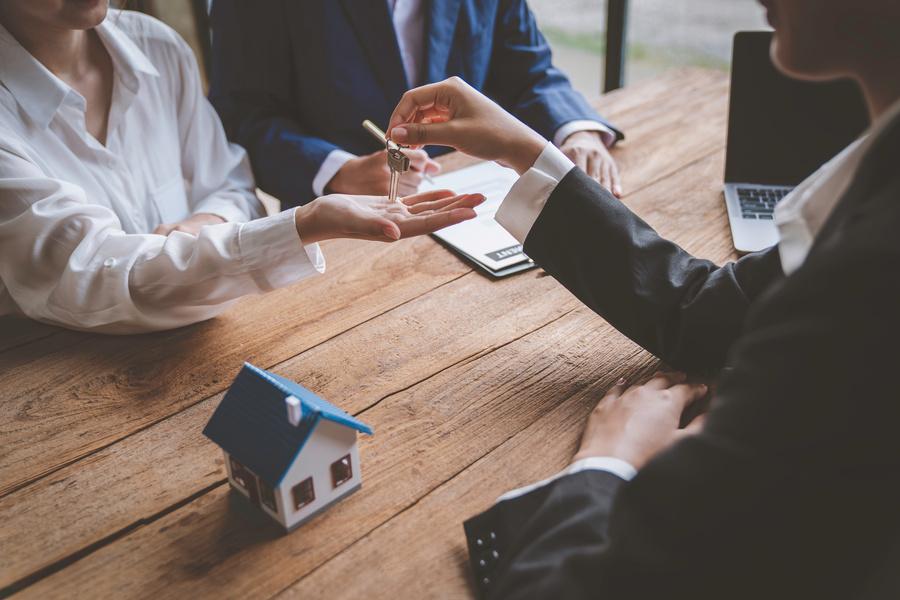 Makler übergibt einer Frau die Schlüssel