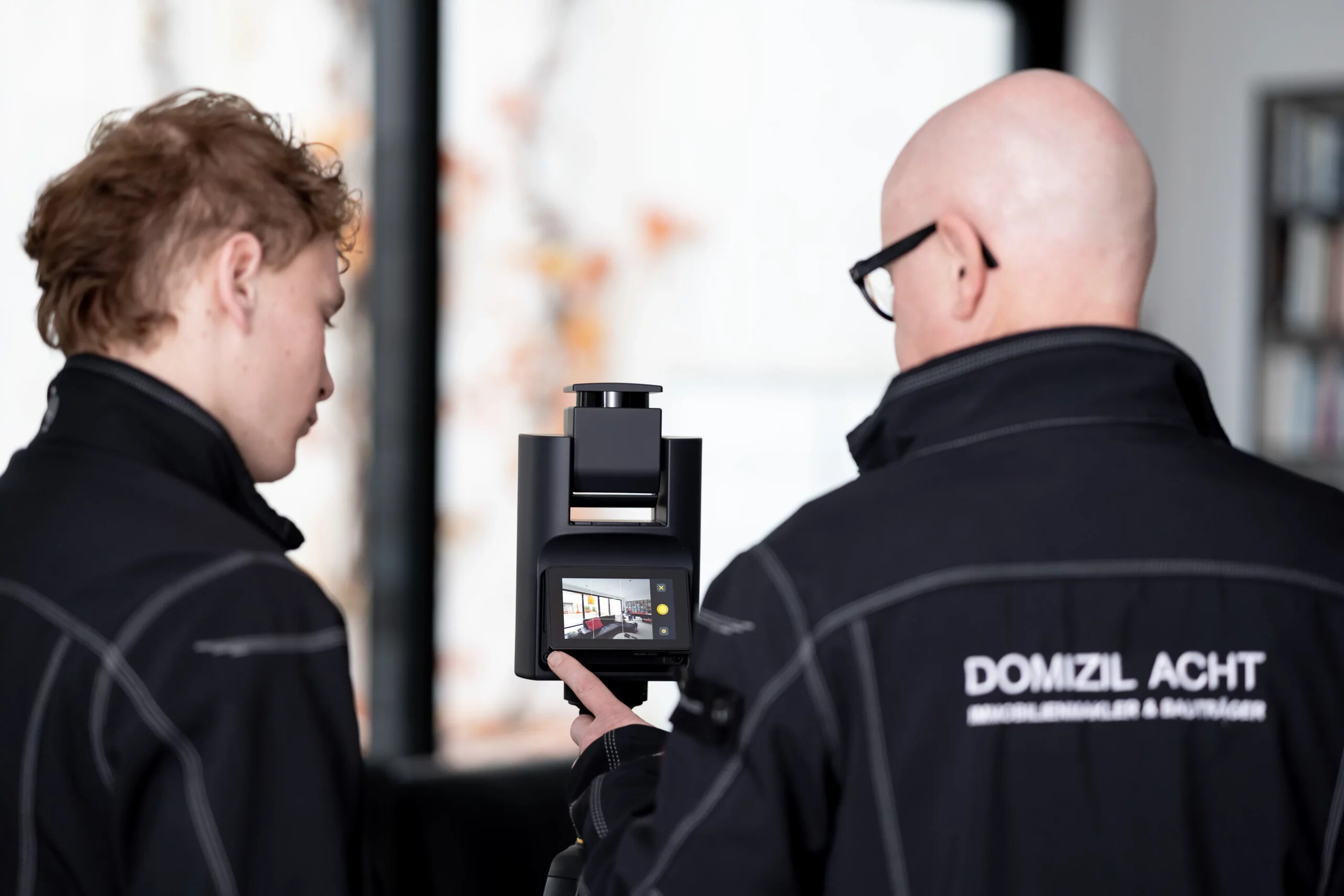 Zwei Personen fotografieren einen Raum mit einer professionellen Kamera