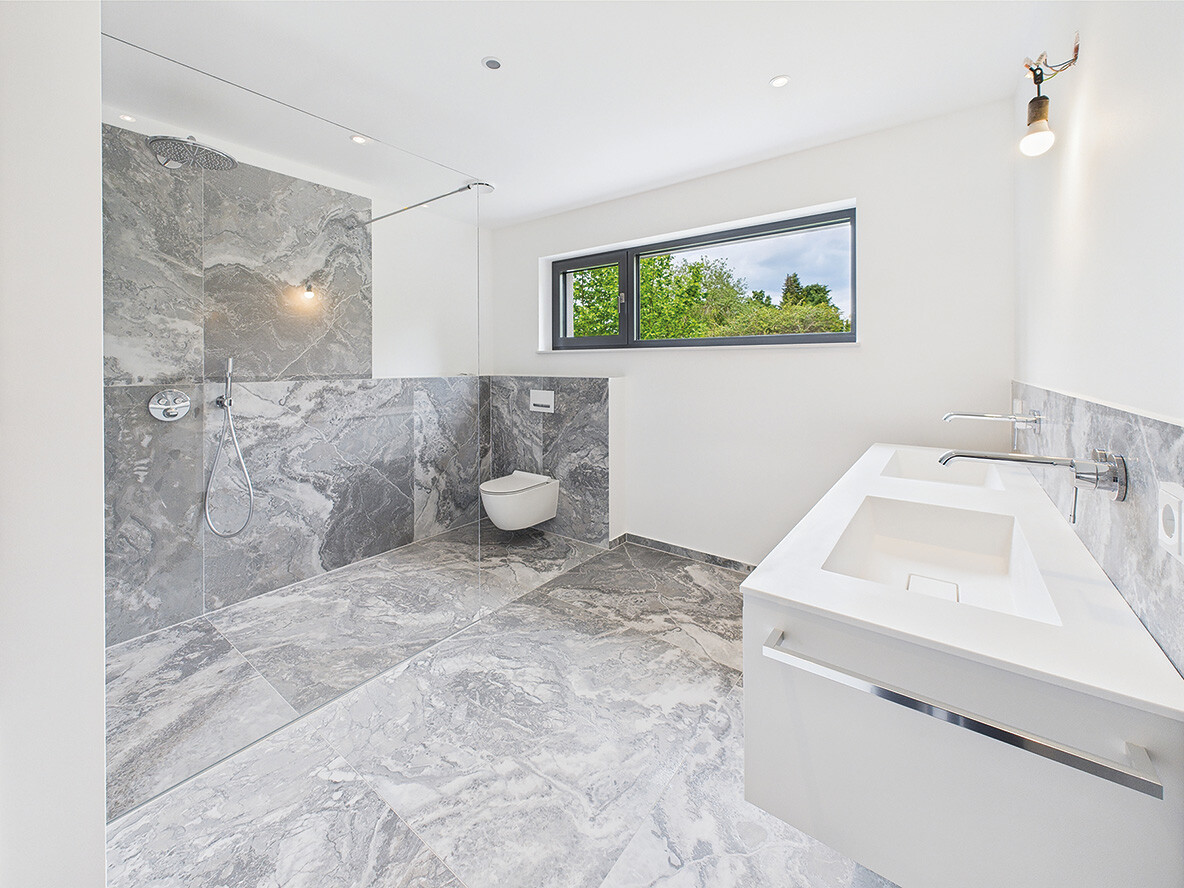 Badezimmer mit Fenster und Marmorfliesen